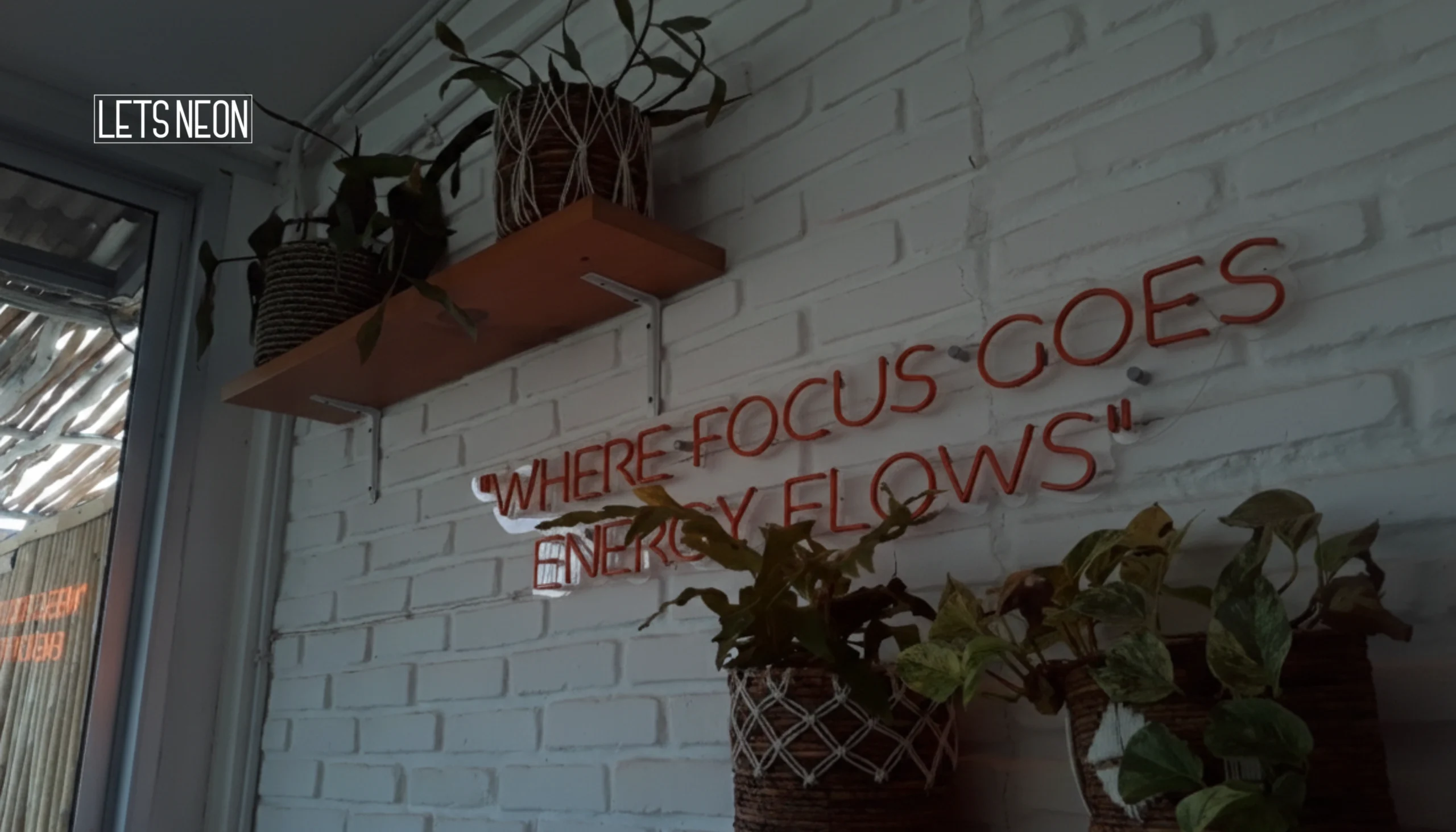 Custom neon signs mounted on wall during the day.